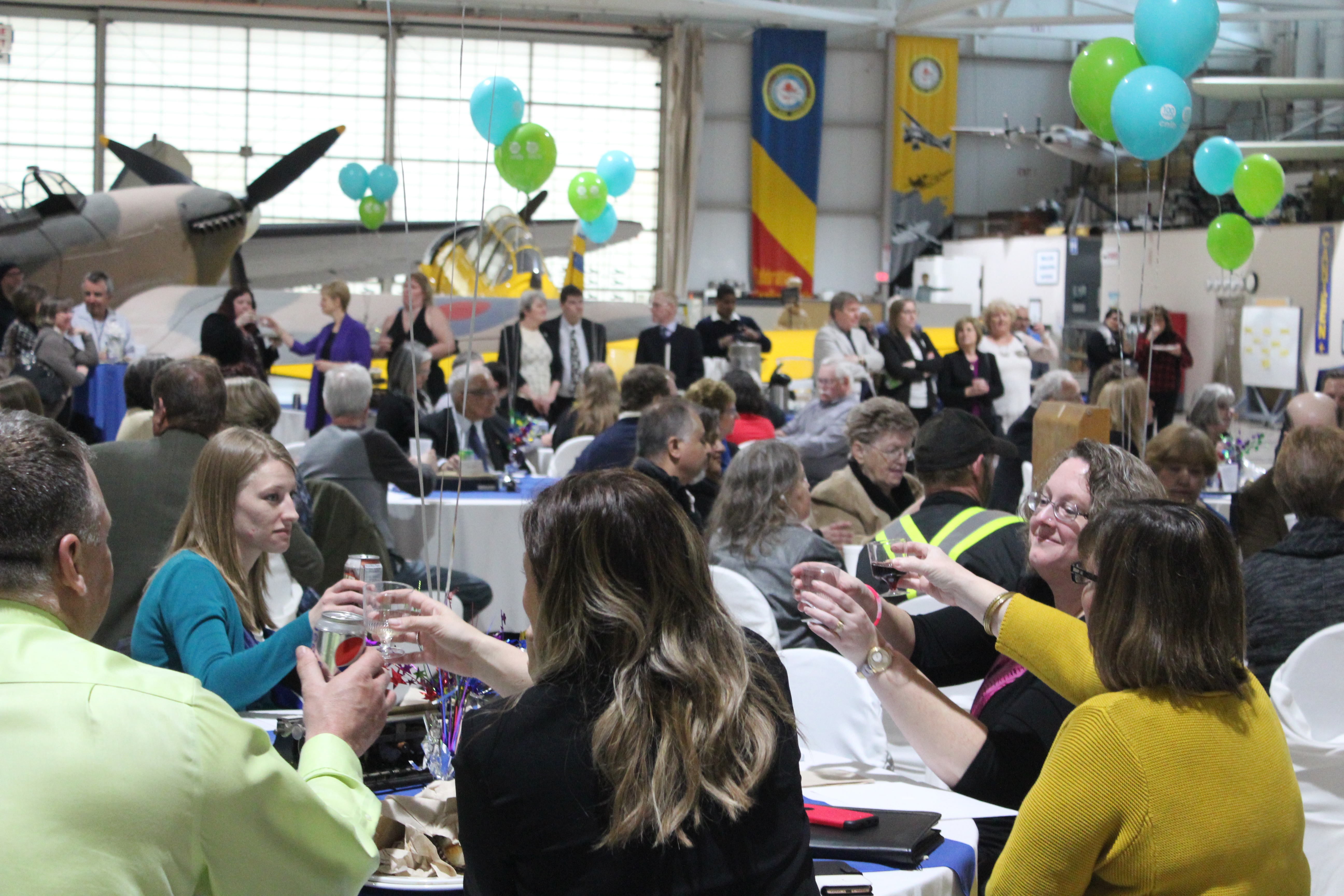 Des gens assis à des tables dans un cadre festif.