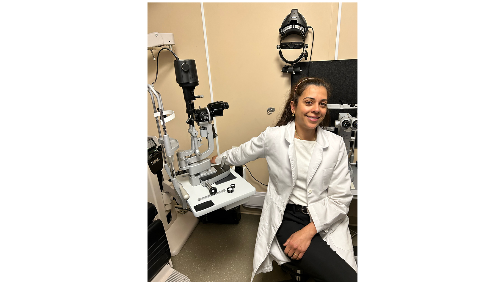 Dr. Danah Al-Breiki, Opthamologist sitting in a doctor office with a white lab coat on