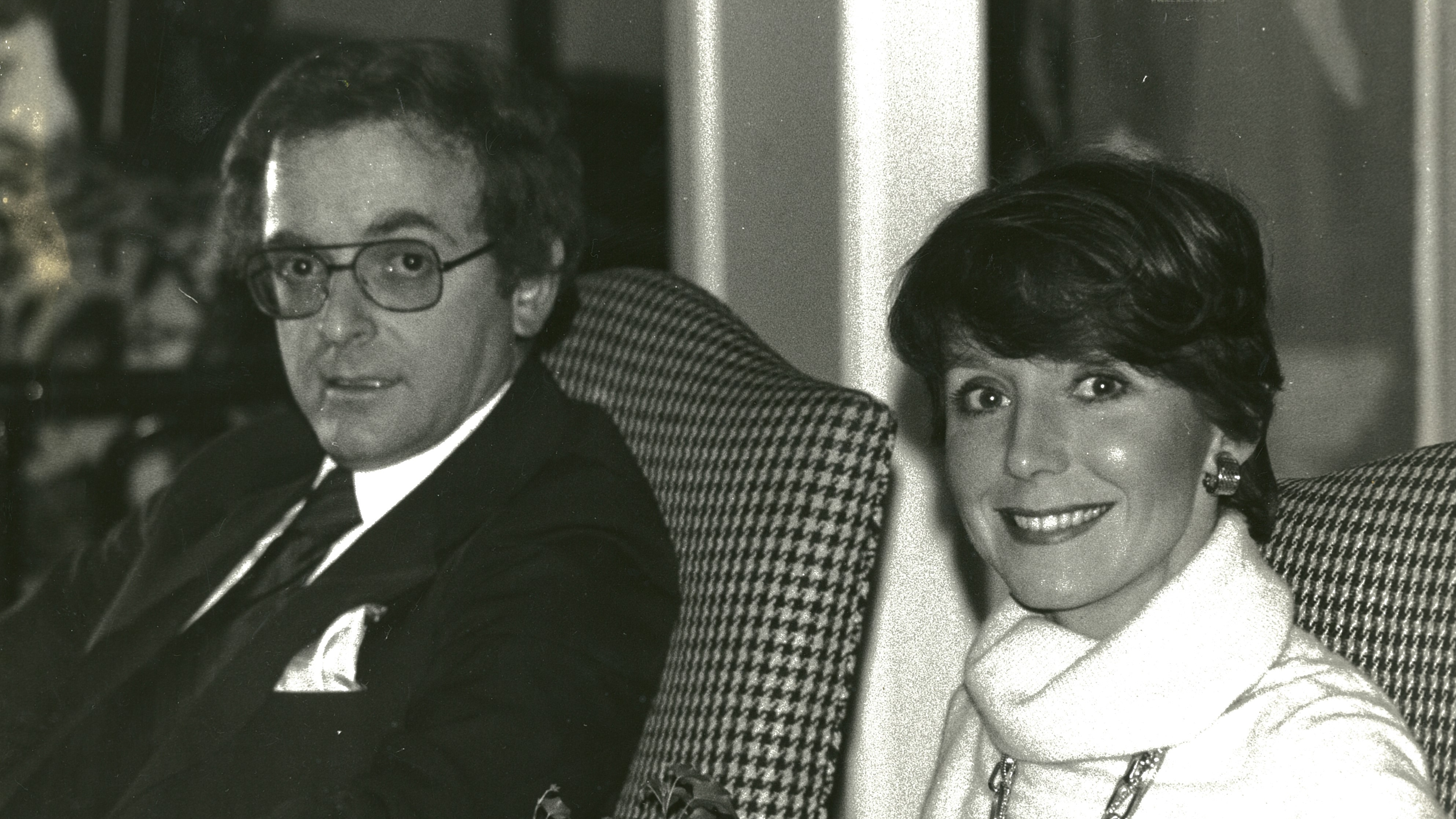 Une photo en noir et blanc d'un jeune Howard et Delores Beck assis sur des fauteuils assortis.