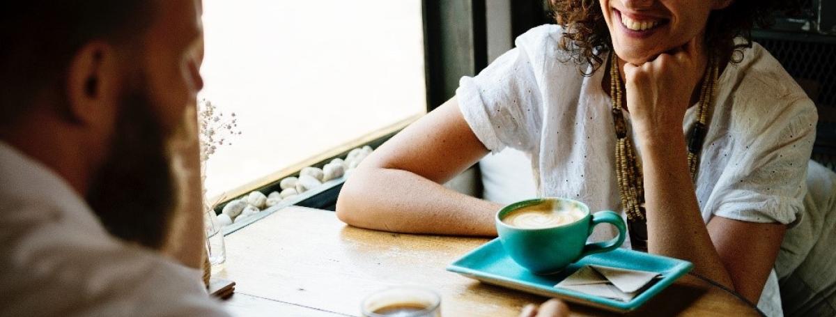 two people sitting at a table drinking coffee