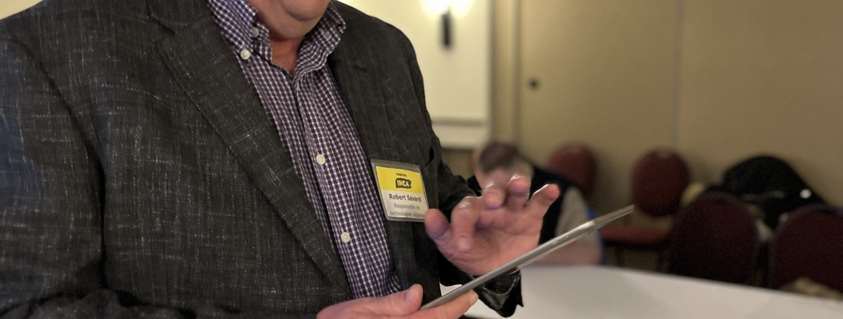 Robert Savard en train de manipuler un iPad.