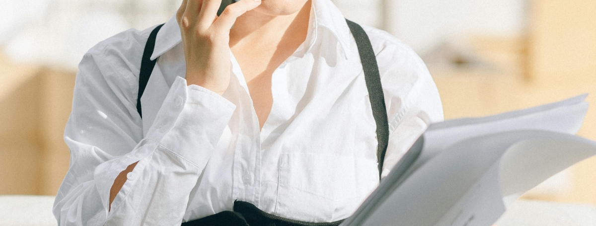 Une jeune femme en tenue professionnelle au téléphone.