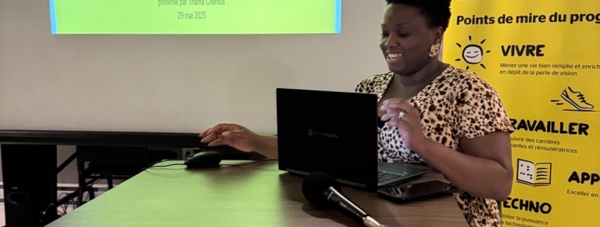 Thama assise derrière une ordinateur et un micro présente un Powerpoint.
