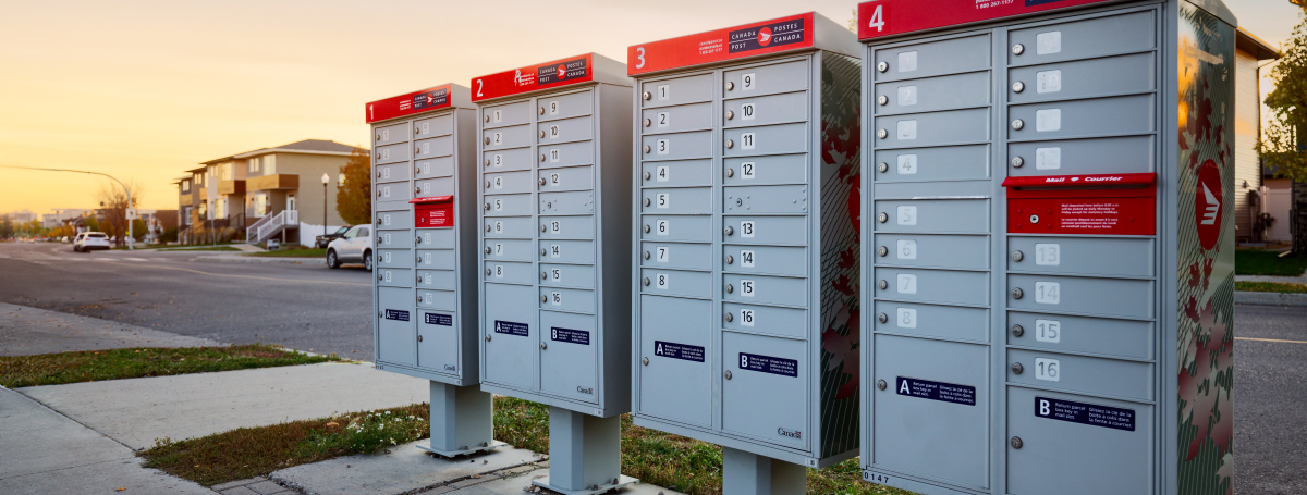 Quatre boîtes aux lettres collectives de Postes Canada situées dans un quartier résidentiel