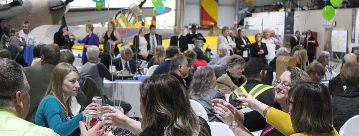 Des gens assis à des tables dans un cadre festif.