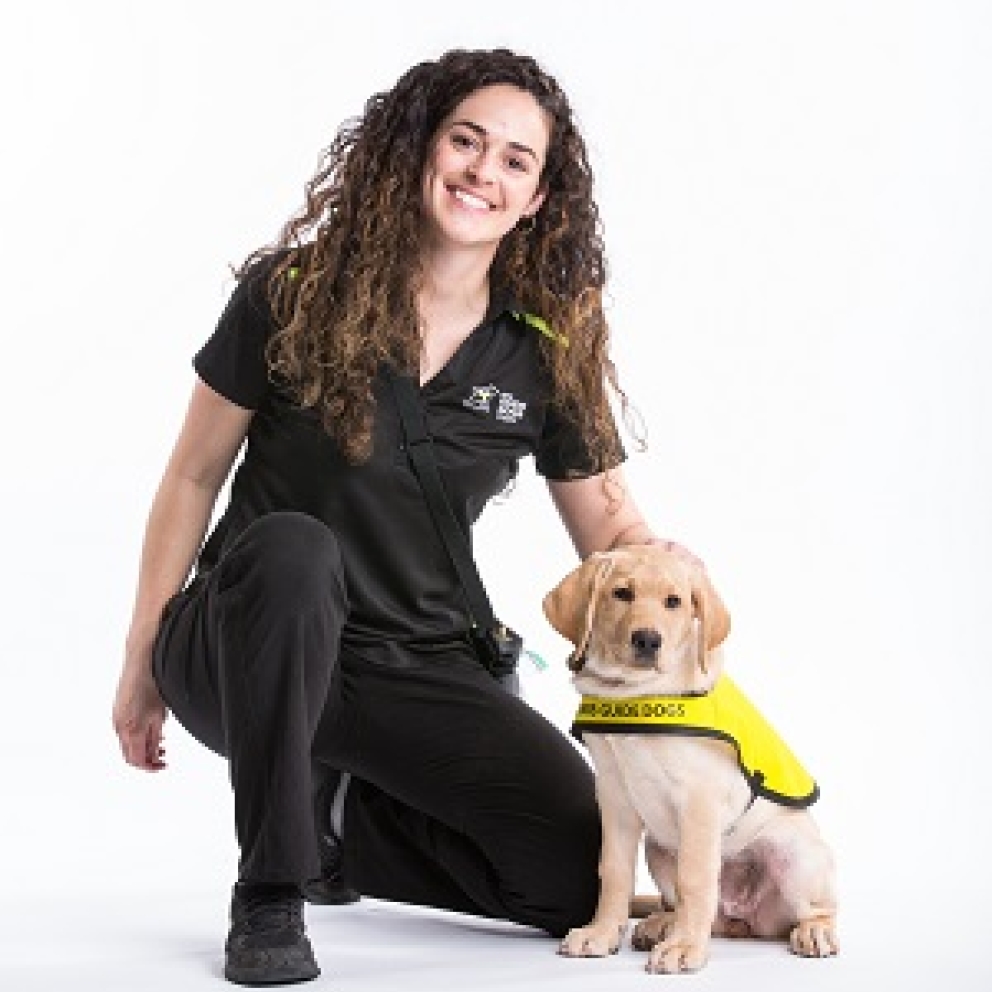 Un chiot chien-guide d'INCA en formation avec son maître souriant