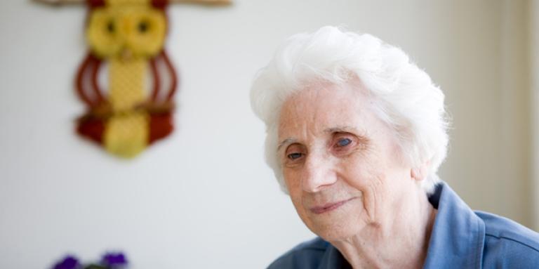 Elderly woman smiling sitting while sitting down. 