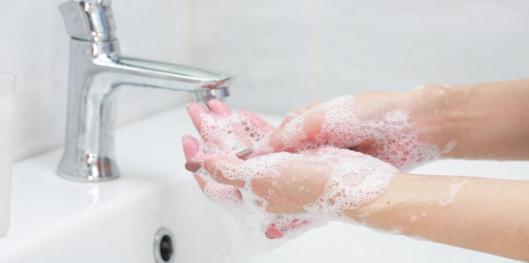 Des mains, bien savonnées, sont rincées à l'évier.
