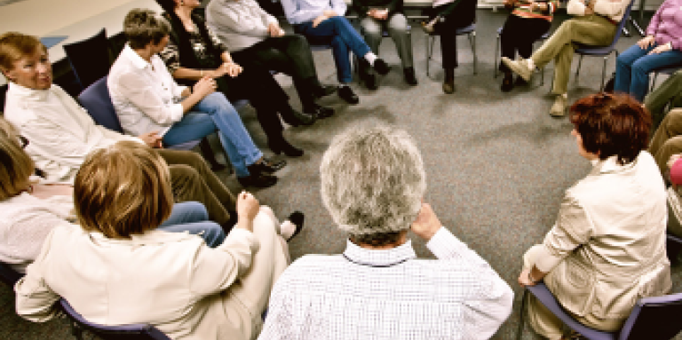 Groupe de personnes assises sur des chaises en cercle.