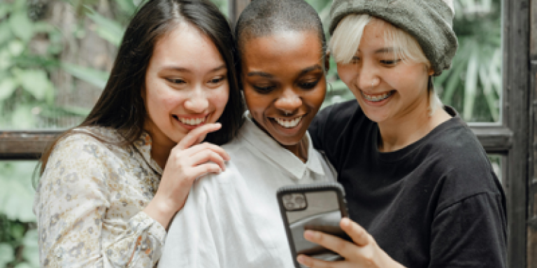 Trois jeunes femmes sur un téléphone cellulaire