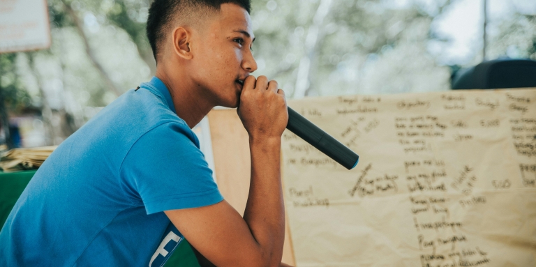 Un jeune homme qui parle au micro.
