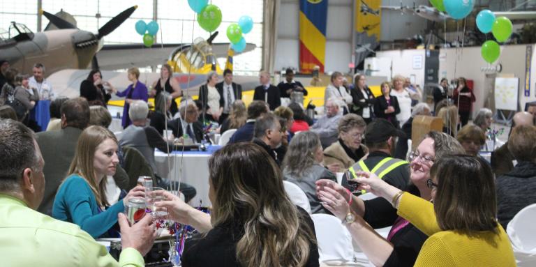 Des gens assis à des tables dans un cadre festif.