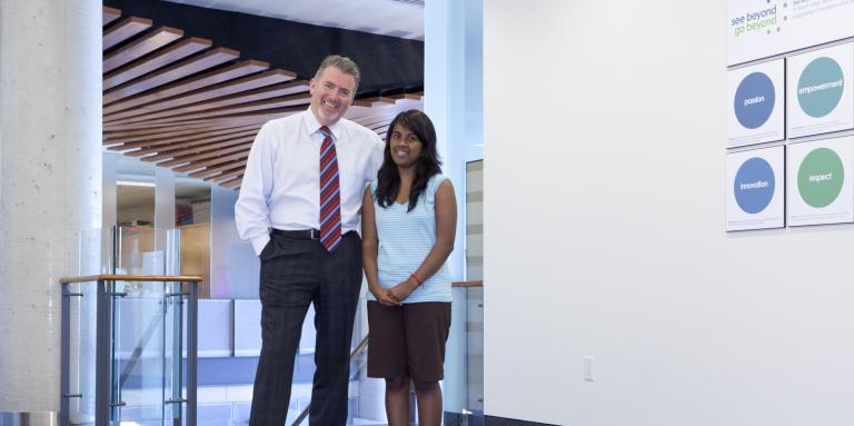 Older man and young woman standing next to each other in an empty hallway