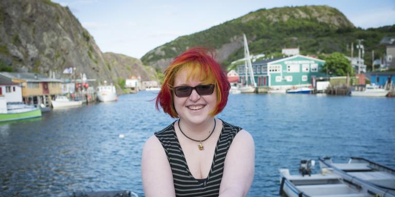 Young woman stands in front of waterfront 