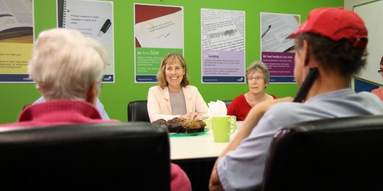 A group of four people sit at a table and engage in lively conversation. 