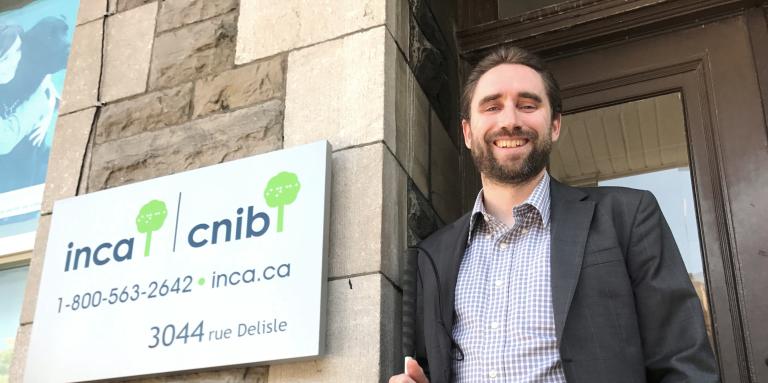  David Demers fier sa canne à la main, en face des anciens bureaux d'INCA.