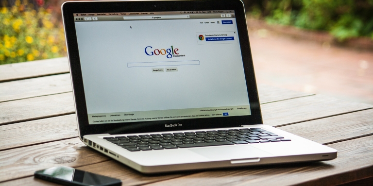 Ordinateur posé sur une table à l'extérieur avec page de recherche Google