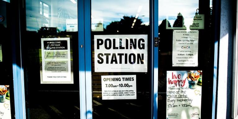 Une porte extérieure avec un panneau "Polling Station" dans la fenêtre.