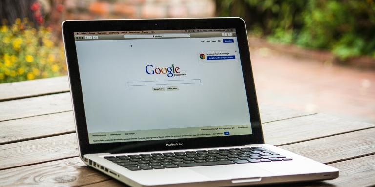 Ordinateur portable posé sur une table à l'extérieur avec page de recherche Google