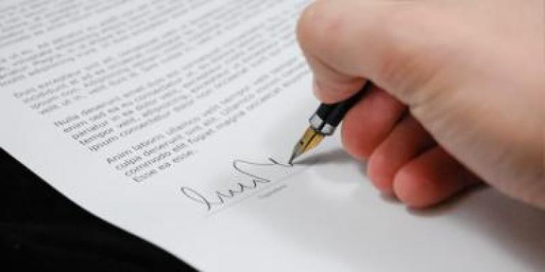 Une main qui signe un document.
