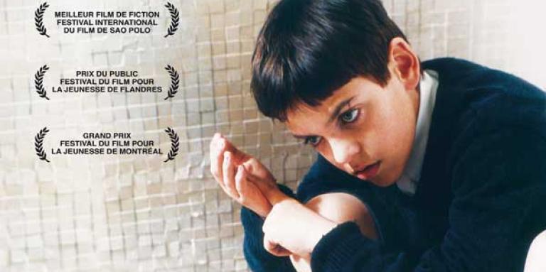 Affiche du film « Rouge comme le ciel » : image d’un enfant accroupi à côté d’un magnétophone.