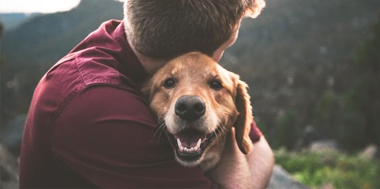 Un homme qui serre un chien.