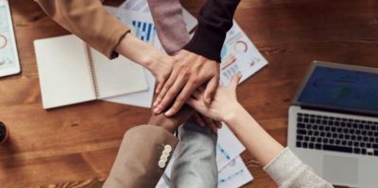Les mains dans un cercle, jointes ensemble, signifiant la coopération