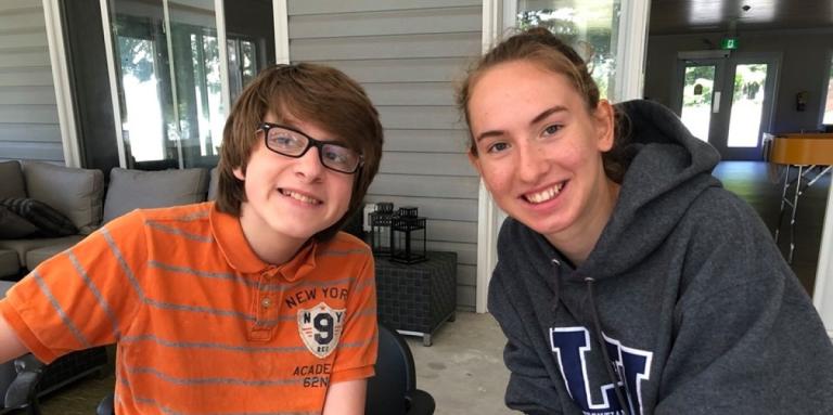 Camper (boy) and Camp Counsellor (young woman) smiling