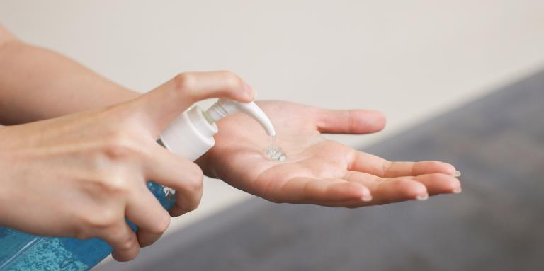 Une personne utilise du désinfectant pour les mains d’une bouteille