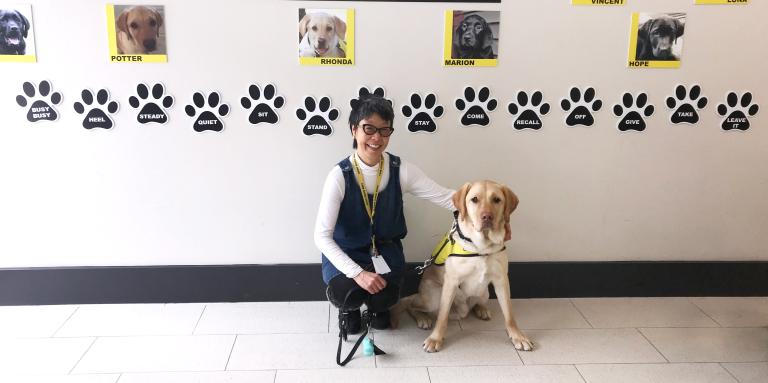 Yuko Imai, éleveuse de chiots, agenouillée à côté de Potter, un futur chien-guide d’INCA.