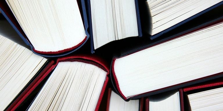 Image showing a group of multi-coloured, thick textbooks from the top