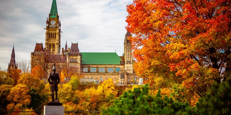Photo du Parlement du Canada avec les feuilles d'automne au premier plan