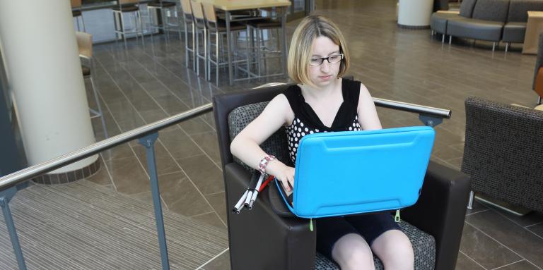 Une jeune femme vivant avec une perte de vision utilise un ordinateur