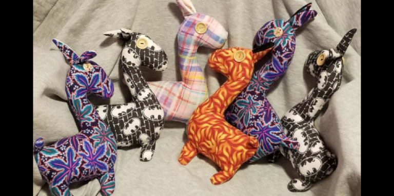 Six colourful stuffed animal Llamas, created by Jaclyn. The llamas have tactile elements like button eyes. 