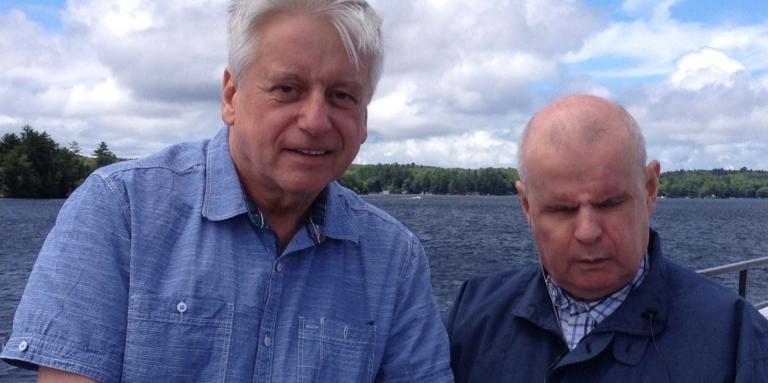 Rob Froom (à gauche) debout au bord du lac Joe avec son frère David. Rob tient la main de son frère.