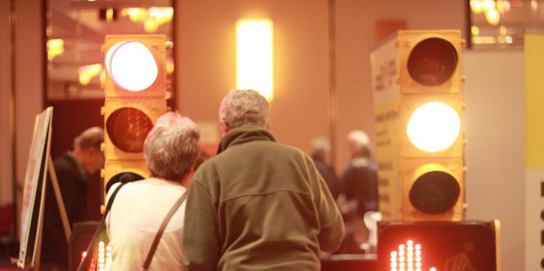 Un homme et une femme grisonnant à un kiosque avec des lumière de rue.
