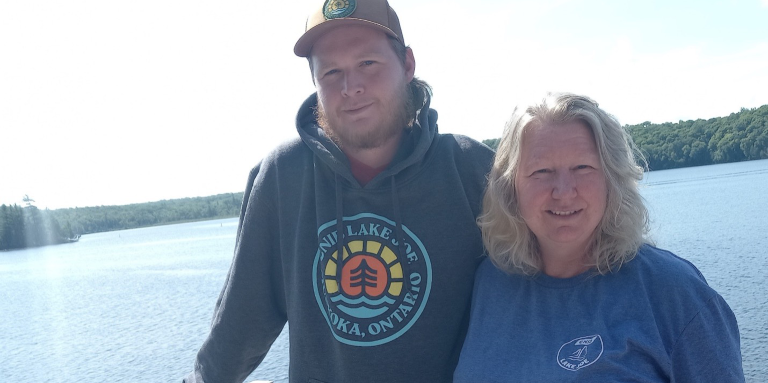 Kathy et son fils Clayton se tiennent sur le balcon de leur chalet, au bord de l’eau.