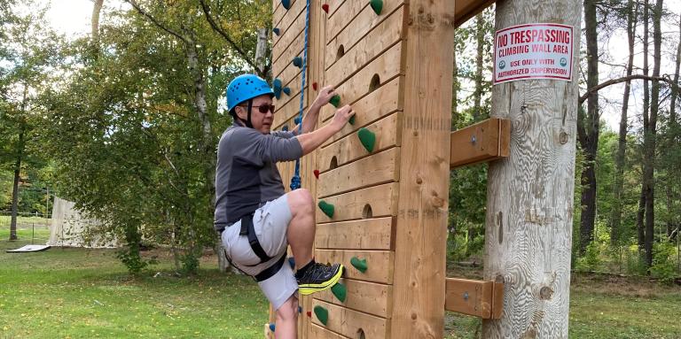 A participant scales the climbing tower at CNIB Lake Joe. 