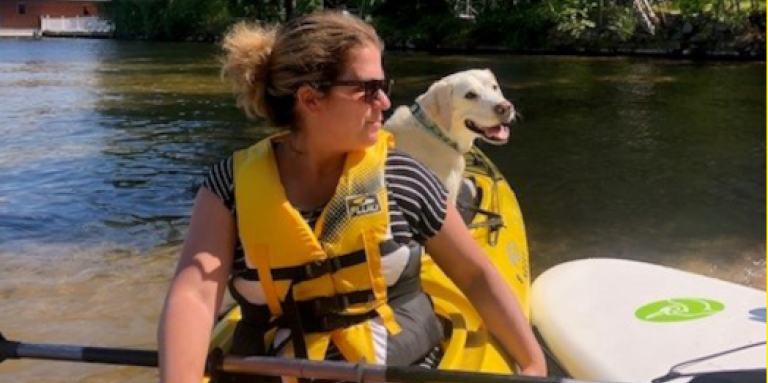 Alessia Tuilli avec son chien guide dans un kayak sur l'eau au lac Joe d'INCA