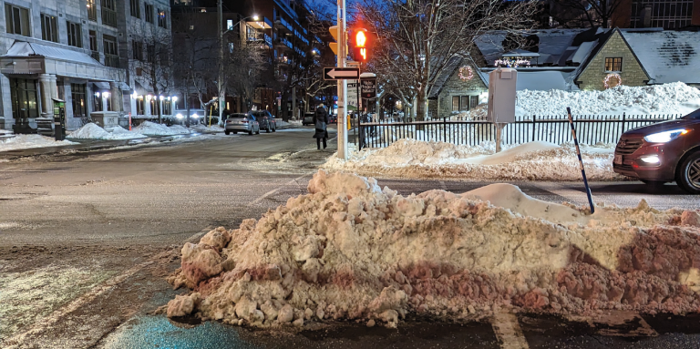 À des feux de circulation, un amoncellement de neige mal déblayé bloque l’accès à la moitié de la traverse de piétons.