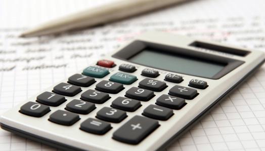 Plan rapproché d'une calculatrice déposée sur une feuille de calculs