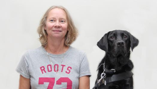 Une femme et son chien guide Labrador-Golden Retriever noir.