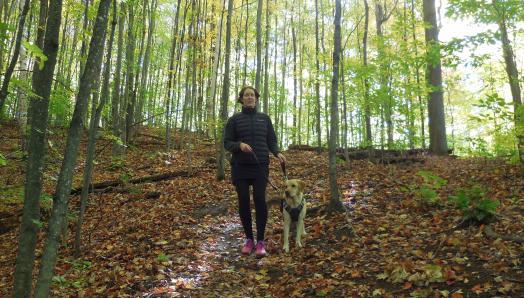 Marie-Claire et Rhonda, marchant dans une forêt verte et luxuriante - le sol couvert de feuilles d'automne multicolores.