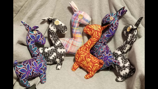 Six Llamas en peluche colorés. Les lamas ont des éléments tactiles, comme des yeux en forme de boutons.