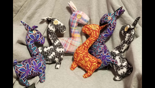 Six colourful stuffed animal Llamas, created by Jaclyn. The llamas have tactile elements like button eyes. 