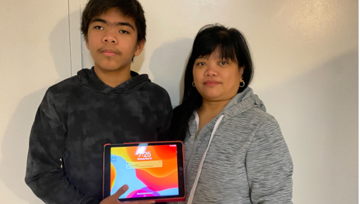 John (left) and Mary (right) stand side by side. John is holding his iPad.