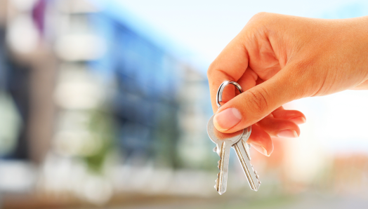 A woman’s right-hand holds a set of apartment keys.