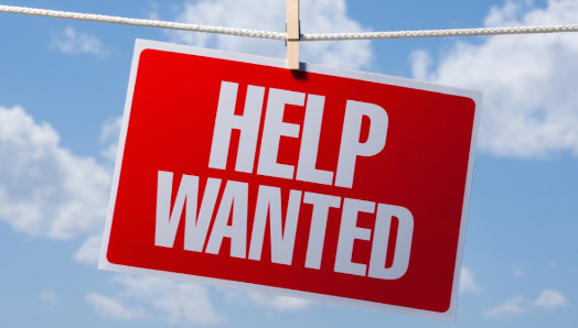  A ‘help wanted’ sign hangs on a clothesline outdoors.