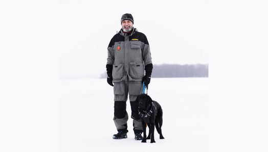 Lawrence et son chien-guide profitent des grands espaces hivernaux. Ils se tiennent ensemble sur un lac gelé recouvert de neige.
