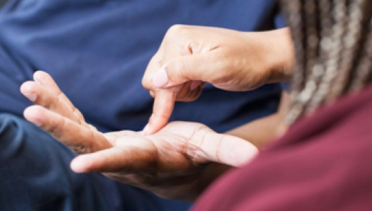 Un intervenant utilise l’alphabet tracé sur la paume pour communiquer avec un client.